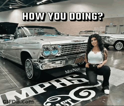 A Woman Kneeling In Front Of A Car With The Words How You Doing Written On It GIF
