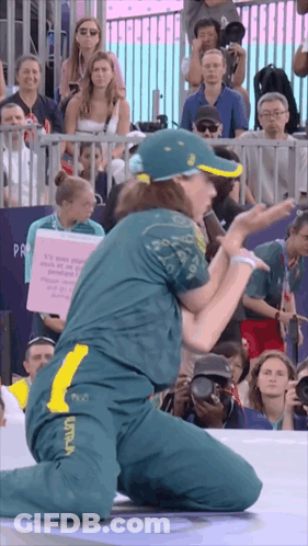 A Woman Kneeling In Front Of A Crowd Holding A Sign That Says ' It 'S Your People ' On It GIF