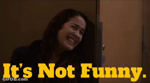 A Woman Laughing With The Words " It 'S Not Funny " Behind Her GIF