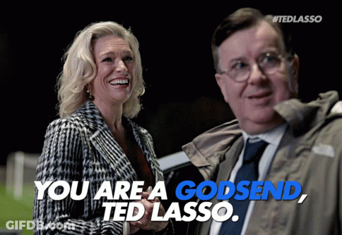 A Woman Laughs Next To A Man Who Says You Are A Godsend GIF