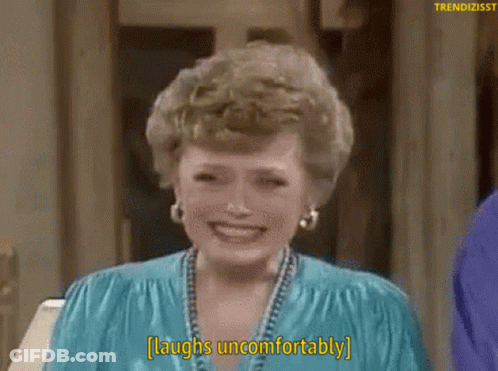 A Woman Laughs Uncomfortably While Wearing A Blue Shirt GIF