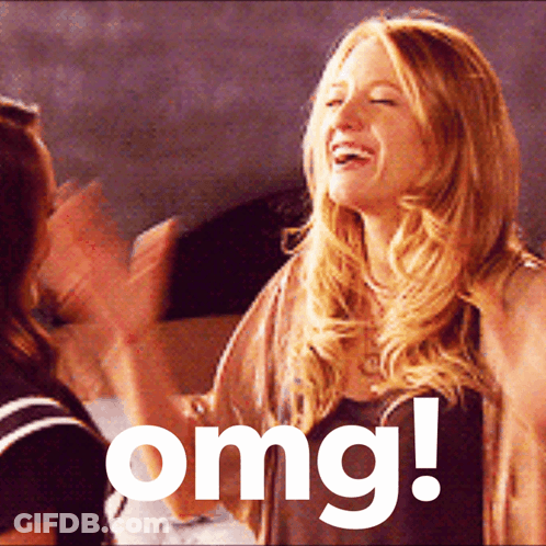 A Woman Laughs While Another Woman Applauds In Front Of A Sign That Says " Omg " GIF