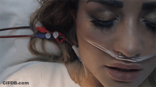 A Woman Laying In A Hospital Bed With An Oxygen Mask On Her Nose GIF