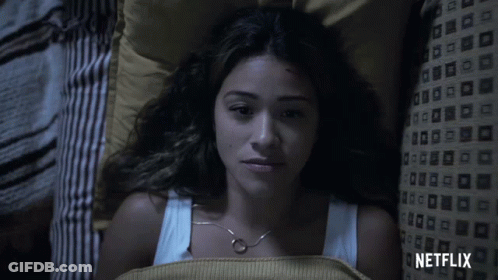 A Woman Laying In Bed With A Netflix Logo On The Bottom GIF