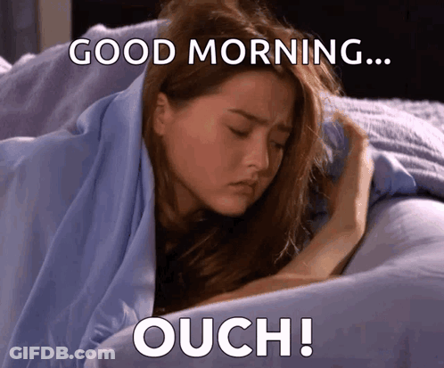 A Woman Laying In Bed With The Words Good Morning Ouch Written Below Her GIF