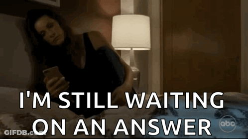 A Woman Laying On A Bed Looking At Her Phone With The Words I 'M Still Waiting On An Answer GIF