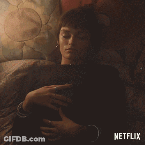 A Woman Laying On A Bed With A Netflix Logo On The Bottom GIF