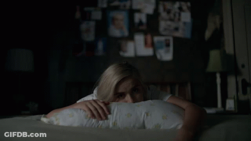 A Woman Laying On A Bed With A Pillow On Her Head GIF