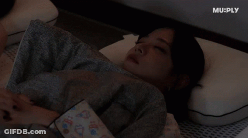 A Woman Laying On A Bed With Muply Written On The Bottom Right GIF