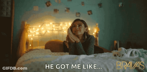 A Woman Laying On A Bed With The Words He Got Me Like Behind Her GIF