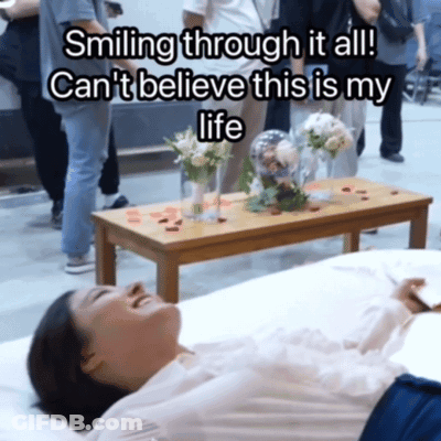 A Woman Laying On A Bed With The Words Smiling Through It All Can 'T Believe This Is My Life Above Her GIF