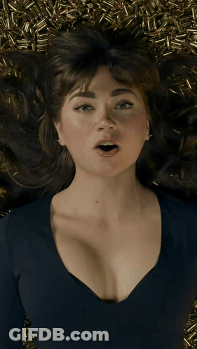 A Woman Laying On A Pile Of Bullets With Her Mouth Wide Open GIF