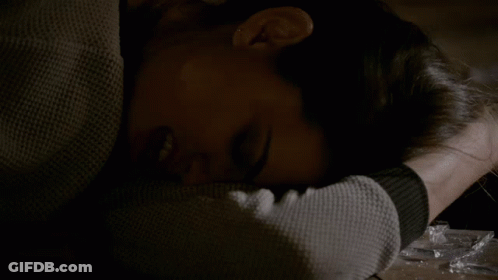 A Woman Laying On A Table With Her Head On Her Arm GIF