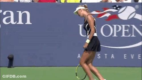 A Woman Laying On A Tennis Court With A Racket GIF