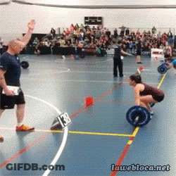 A Woman Lifting A Barbell In A Gym With A Sign That Says 138 GIF