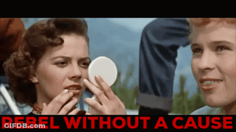 A Woman Looking At Herself In A Mirror With The Words Rebel Without A Cause Below GIF