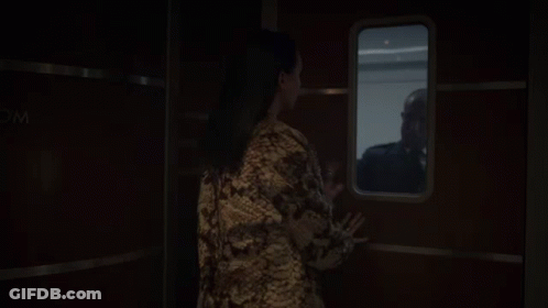 A Woman Looking Out A Window With A Sign That Says Wc GIF