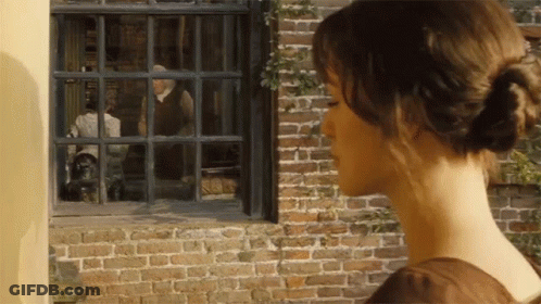 A Woman Looks Out Of A Window At A Man In A Suit GIF