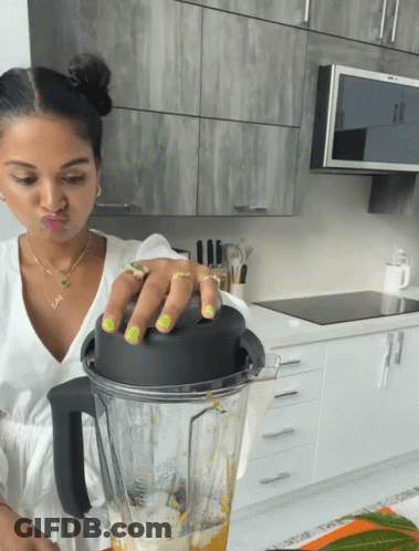A Woman Making A Face While Holding A Blender GIF