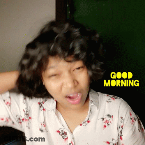A Woman Making A Funny Face In Front Of A Good Morning Sign GIF