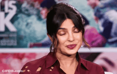A Woman Making A Funny Face In Front Of A Sign That Says K. GIF