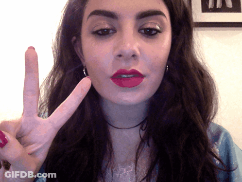 A Woman Making A Peace Sign With Her Hand GIF