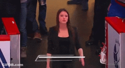 A Woman Named Briannah Donolo Is Smiling While Standing In A Hallway GIF