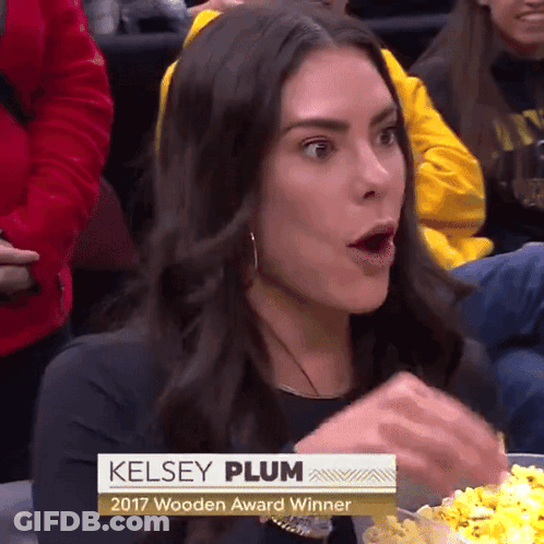 A Woman Named Kelsey Plum Is Eating Popcorn At A Game GIF