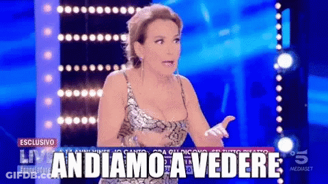 A Woman On A Stage With The Words Andiamo A Vedere On The Screen GIF