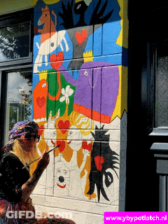 A Woman Paints A Mural On A Wall With The Website Www.ybypotlatch.nl GIF