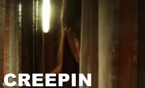 A Woman Peeking Out From Behind A Curtain With Creepin Written In White GIF