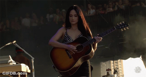 A Woman Playing A Guitar With A Yamaha Logo On It GIF