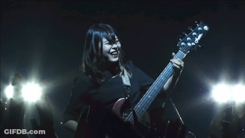 A Woman Playing A Guitar With A Yamaha Logo On The Headstock GIF
