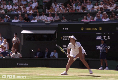 A Woman Playing Tennis In Front Of A Rolex Sign GIF