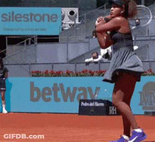 A Woman Playing Tennis In Front Of A Sign That Says ' Silestone ' On It GIF