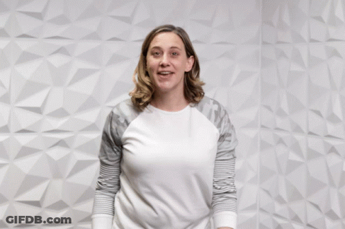 A Woman Pointing At The Camera With The Words " You Rock " Behind Her GIF