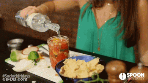 A Woman Pouring A Drink Into A Glass With Spoon University Written On The Bottom GIF