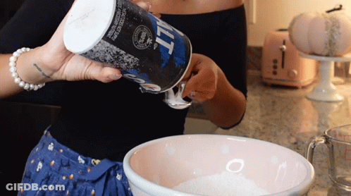 A Woman Pours Salt Into A Bowl Of Flour GIF