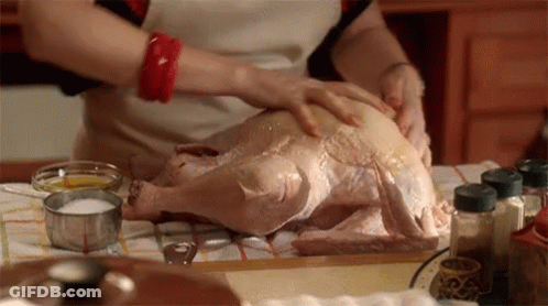 A Woman Prepares A Turkey In A Kitchen GIF