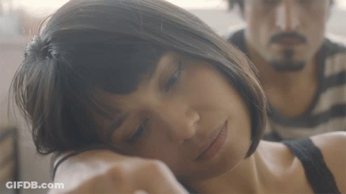 A Woman Rests Her Head On A Man 'S Arm GIF