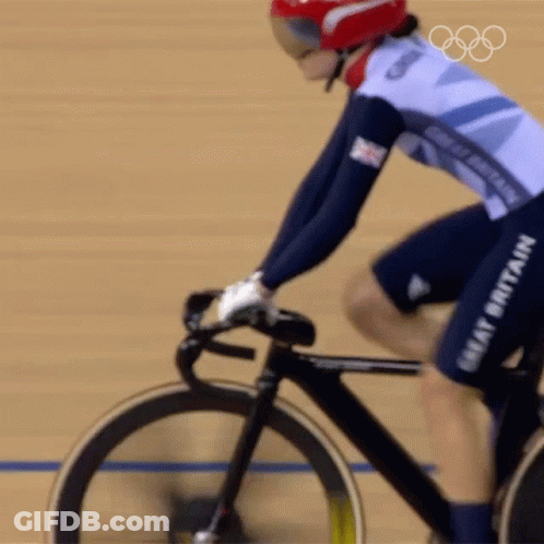 A Woman Riding A Bike With The Word Great Britain On Her Shorts GIF