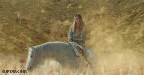 A Woman Riding A Horse In A Field GIF