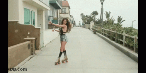 A Woman Rollerblading Down A Sidewalk Holding A Bottle GIF