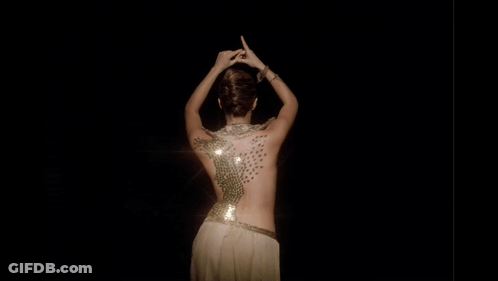 A Woman 'S Back Is Covered In Sequins And Has A Light Shining On Her GIF