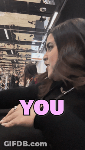 A Woman 'S Face Is Behind A Pink Sign That Says " You " GIF