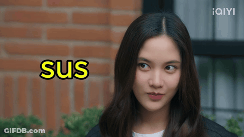 A Woman 'S Face Is Behind A Sign That Says Sus GIF
