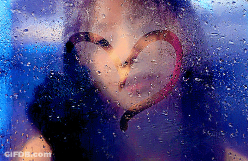 A Woman 'S Face Is Behind A Window With A Heart Drawn On It GIF
