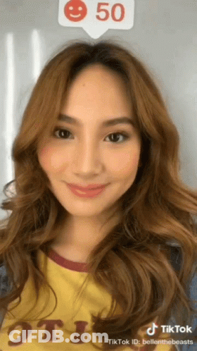 A Woman 'S Face Is Shown In A Tiktok Video With A Smiley Face Above Her Head GIF