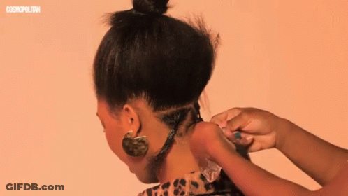 A Woman 'S Hair Is Being Styled In Front Of A Cosmopolitan Ad GIF