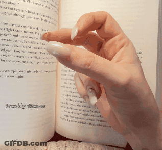A Woman 'S Hand Is Holding A Book Open To A Page That Says Brooklynbones On It GIF